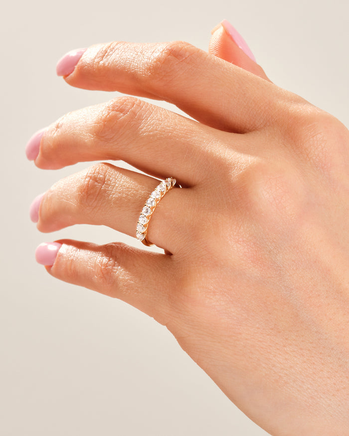 Nine stone moissanite trellis band in yellow gold worn on a hand