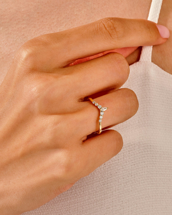 Marquise moissanite curved wedding band worn on the finger, yellow gold