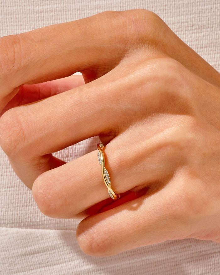 Twisted vine moissanite wedding band worn on the finger, yellow gold