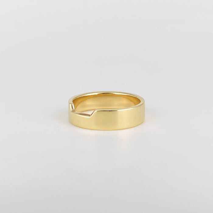 Plain wide contour wedding band with a notched top edge in yellow gold, angled view