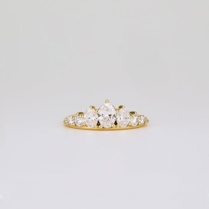 Oval and round moissanite graduated wedding band in yellow gold, front view