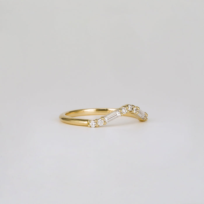 Baguette and round moissanite curved wedding band in yellow gold, side view