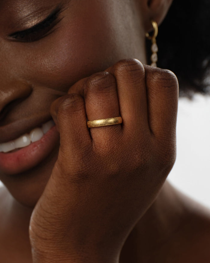 4mm ice matte dome band worn on a smiling model's hand