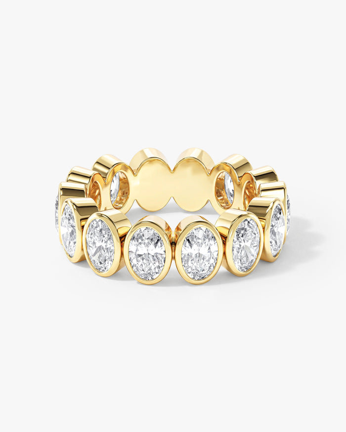 Oval moissanite bezel eternity wedding band in yellow gold, front view