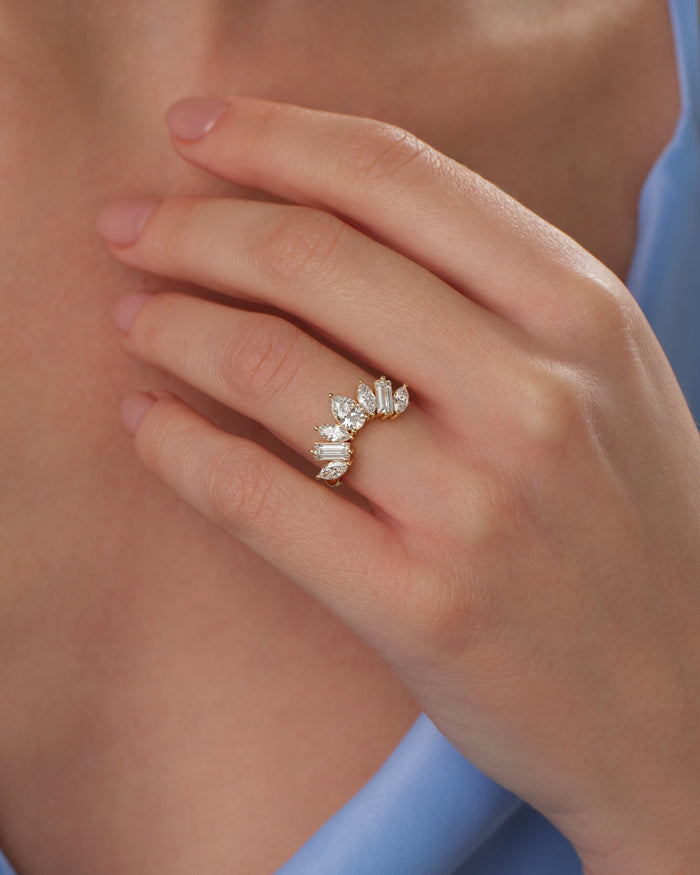 Arched crown moissanite wedding band with pear and baguette stones worn on a hand