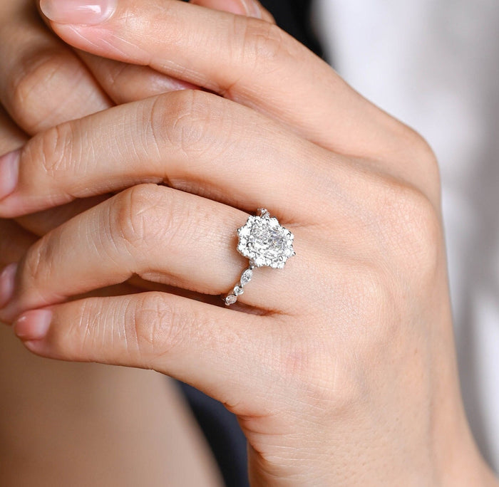 Radiant cut moissanite cluster halo engagement ring with larger round stones at four points and a band of alternating marquise and round stones in white gold, view 2