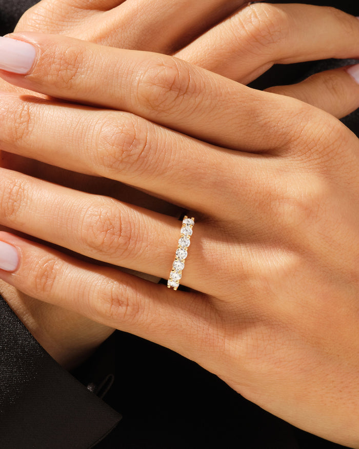 Seven stone moissanite anniversary band worn on a hand
