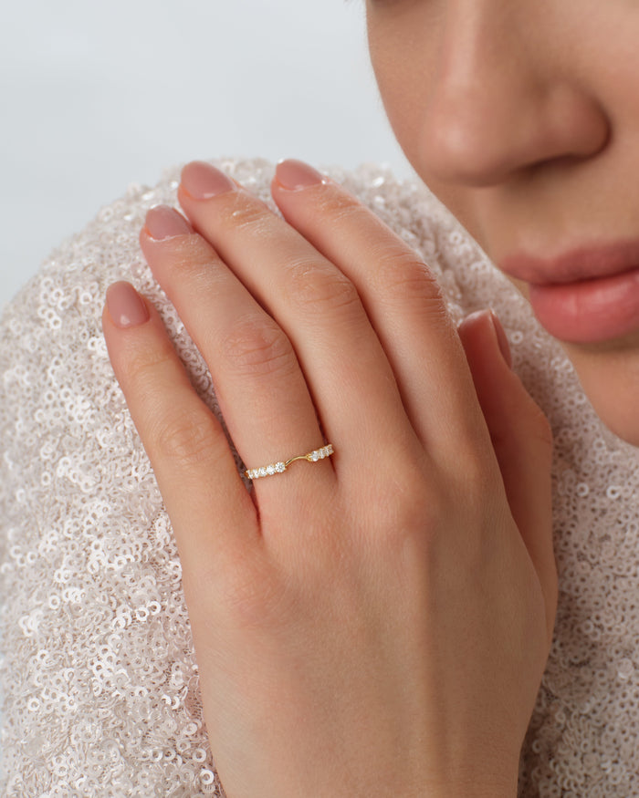 Aura nesting wedding band worn on a hand held at the shoulder