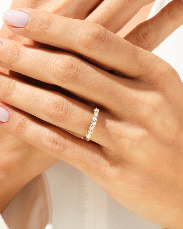 Seven stone moissanite anniversary band worn on a hand
