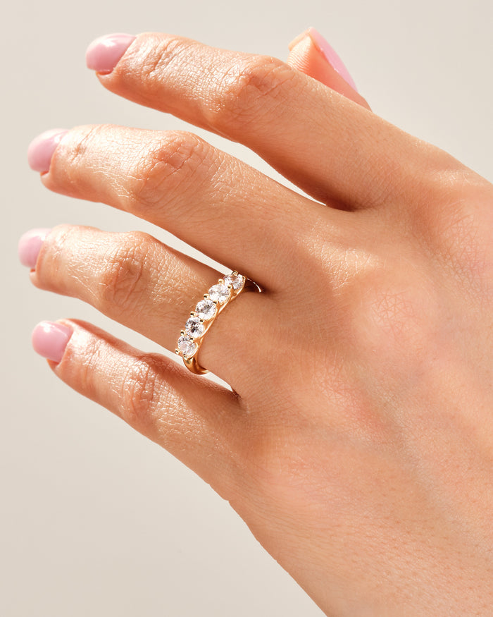 Five stone moissanite trellis band worn on a hand