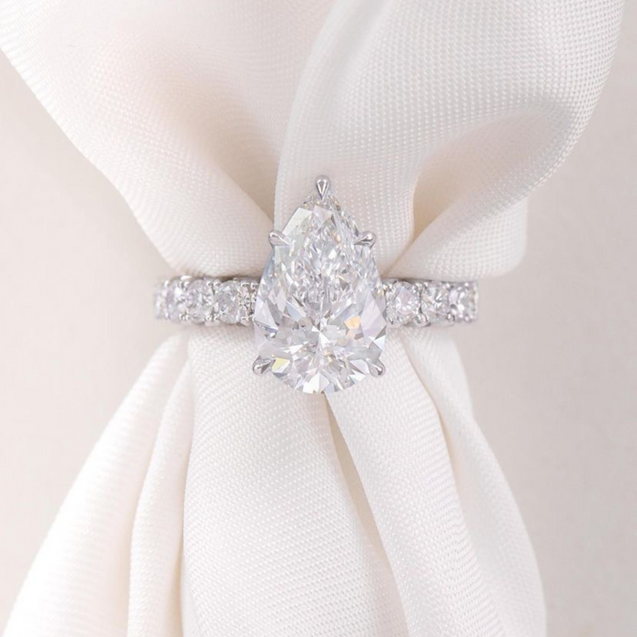 Pear cut moissanite hidden halo engagement ring in gold