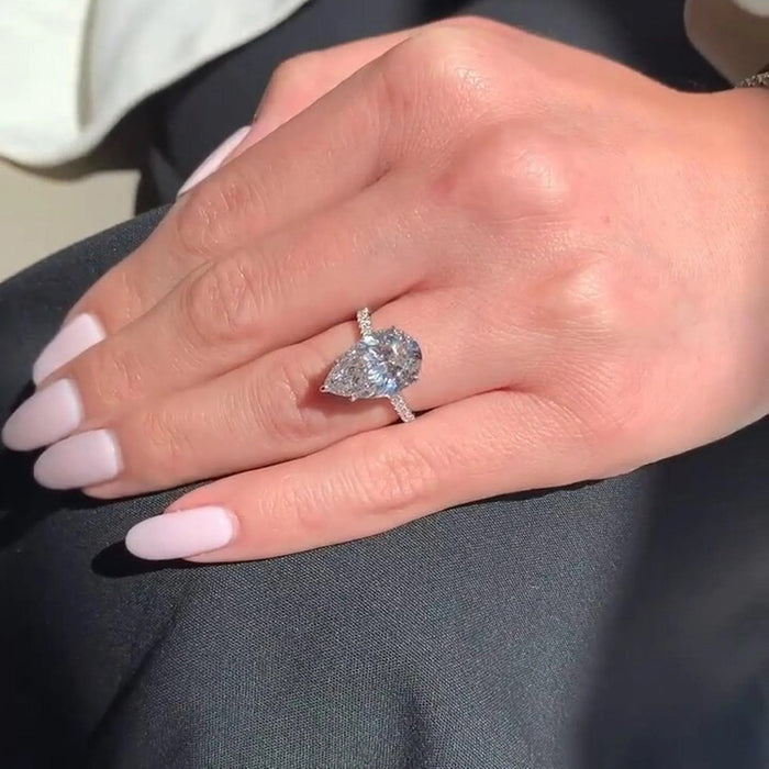 Pear moissanite hidden halo pave ring on hand in white gold — Mapple Gems