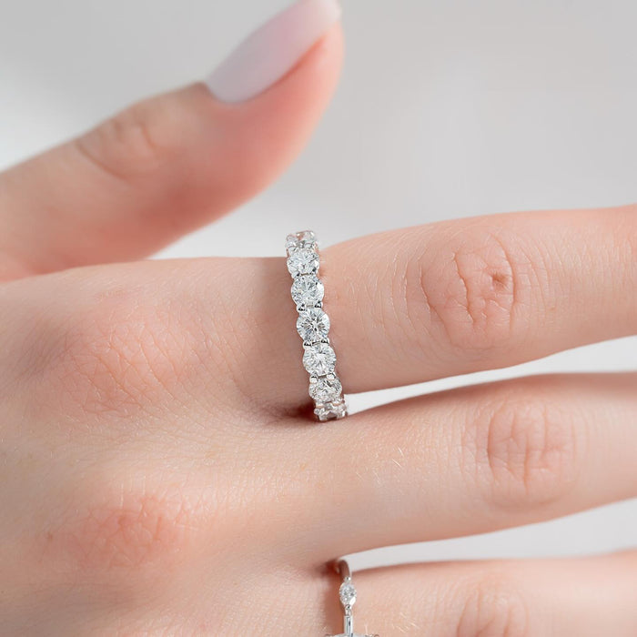 Round moissanite eternity band worn on finger