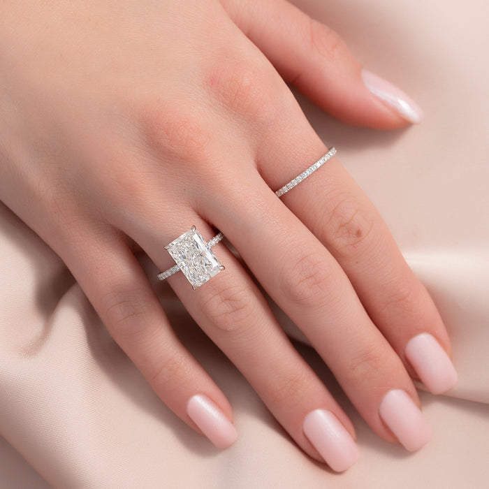 Elongated radiant cut lab grown diamond ring with micro pave shank in white gold worn on the hand
