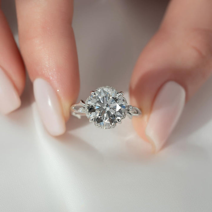 Pave halo around the round brilliant centre diamond with leaf accents