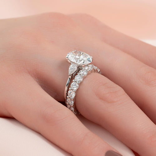 East west oval lab grown diamond bridal ring set with pear side stones in white gold worn on the hand