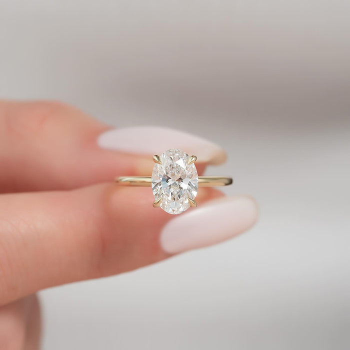 Oval cut lab grown diamond ring with ultra thin yellow gold band and tapered claws