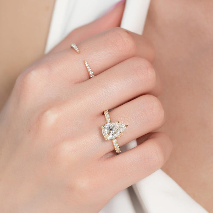 Pear cut lab grown diamond pave shank engagement ring worn on the hand