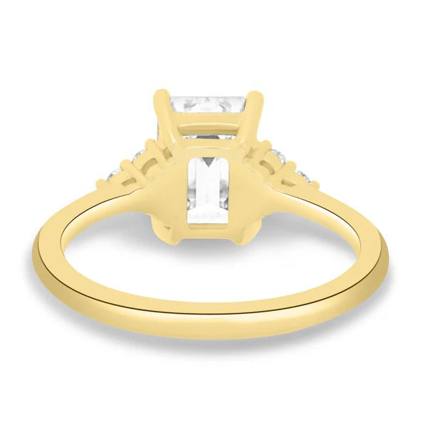 Trefoil cluster of three round accents beside emerald cut diamond