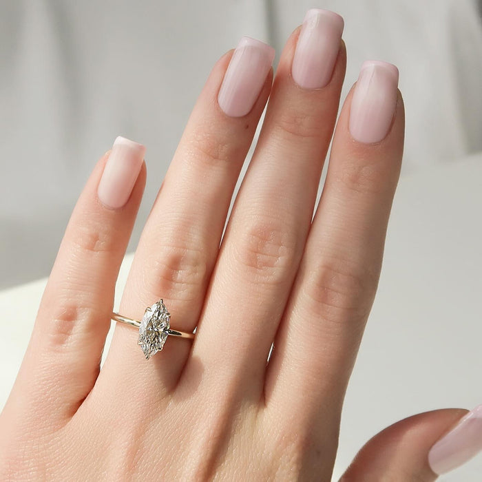 Marquise cut lab grown diamond solitaire ring in yellow gold worn on the hand