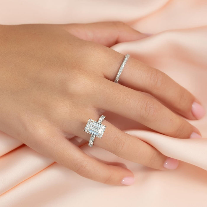 Horizontally set emerald cut diamond engagement ring on hand