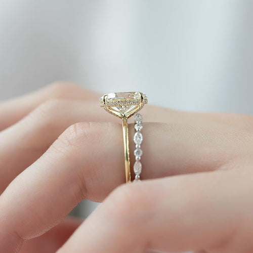 Oval lab grown diamond engagement ring with hidden halo stacked with a marquise accent wedding band in yellow gold