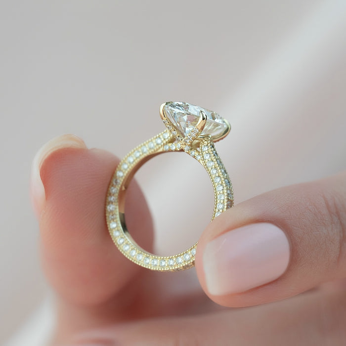 Oval lab grown diamond ring showing the milgrain edges either side of the pave