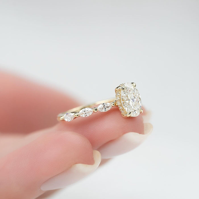 Oval cut lab grown diamond ring in yellow gold on a marquise and bead accent band