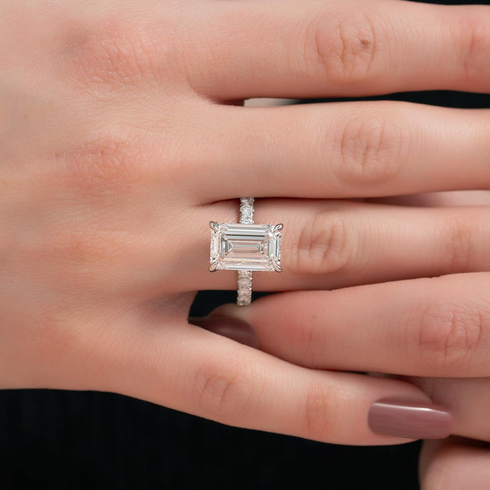 East west emerald cut lab grown diamond ring with micro pave shank in white gold worn on the hand