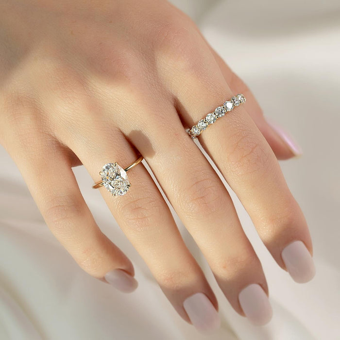 Oval cut lab grown diamond solitaire ring on a plain rounded yellow gold band
