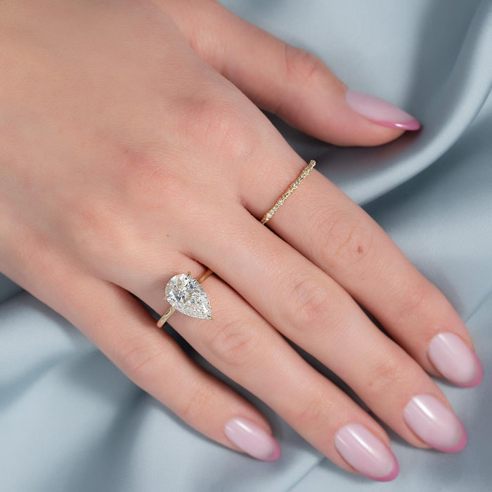 East west pear cut lab grown diamond ring worn on the hand in yellow gold