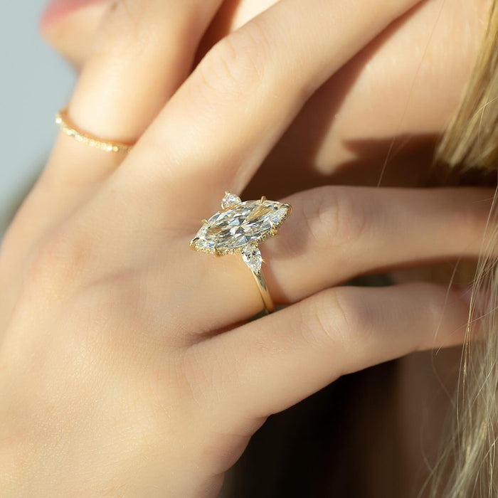 Marquise diamond three stone engagement ring worn on the hand