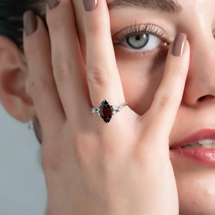Marquise and round diamond clusters at both ends of the garnet