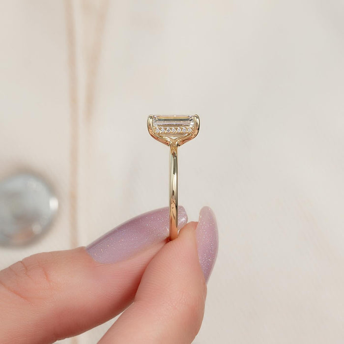 Profile view showing the hidden pave halo beneath the emerald cut diamond