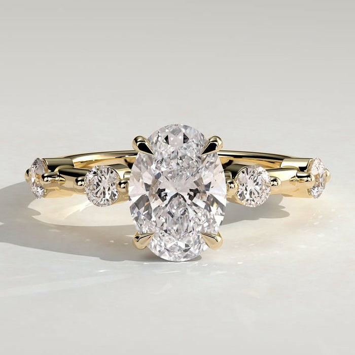 Oval cut lab grown diamond hidden halo ring with spaced round accents in yellow gold