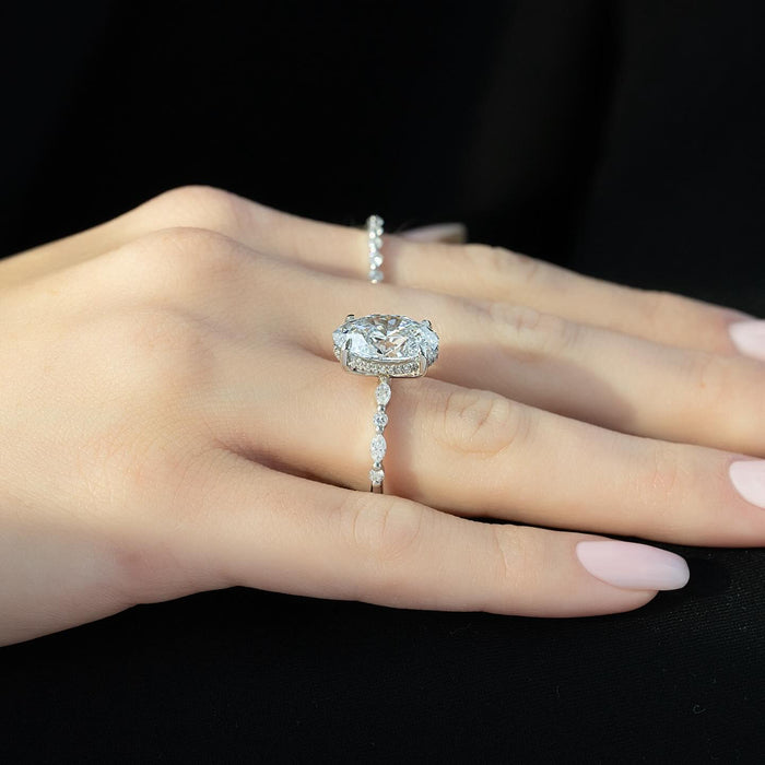 Oval diamond set across the finger with spaced accent stones