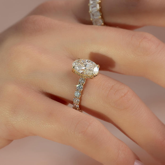 Oval diamond engagement ring with hidden halo worn on the hand