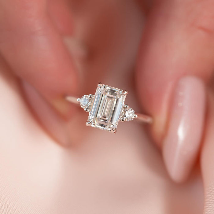 Emerald cut moissanite ring close up with round side stones