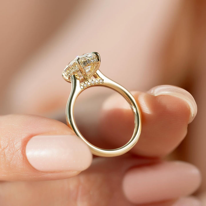 Oval moissanite hidden halo ring side profile showing pave bridge in yellow gold