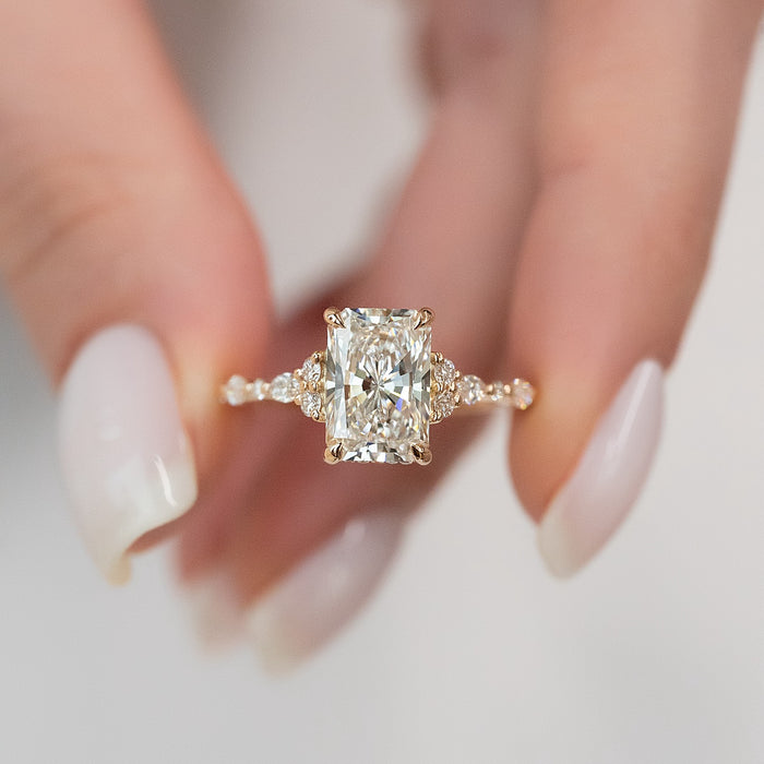 Radiant cut moissanite vintage cluster accent ring close up in rose gold