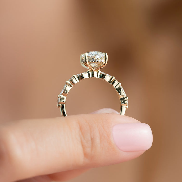 Oval moissanite hidden halo ring profile showing marquise accent band in yellow gold