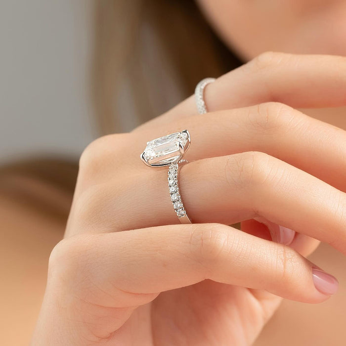 Emerald cut moissanite ring worn east west on hand in white gold