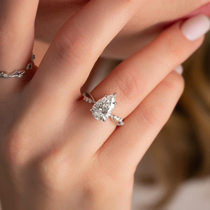 Pear moissanite twisted vine ring worn on hand in white gold