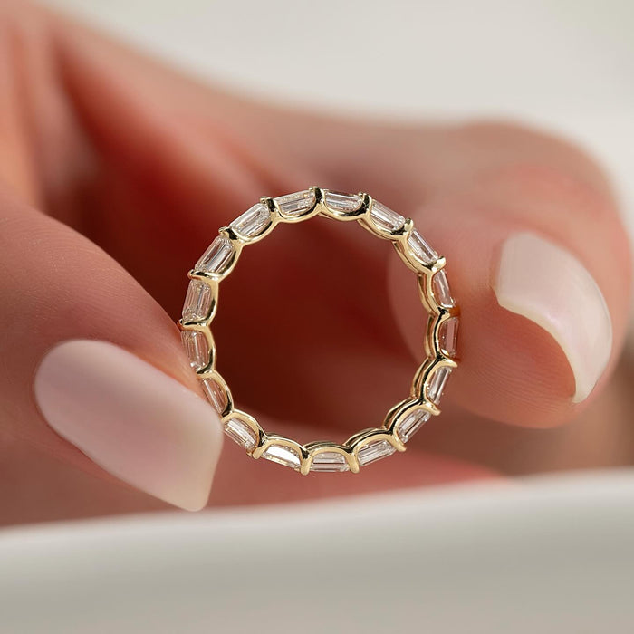 Emerald cut moissanite east west full eternity band in yellow gold