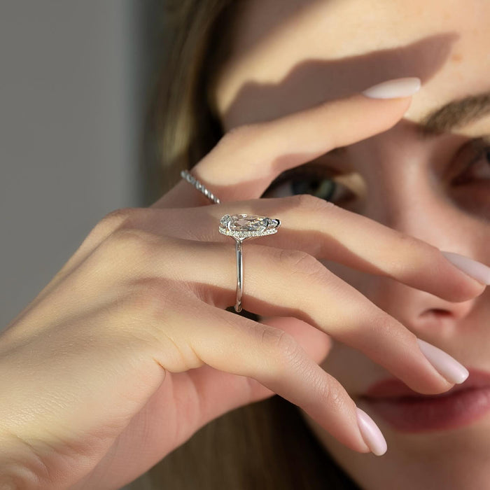 Model wearing pear moissanite hidden halo thin band engagement ring