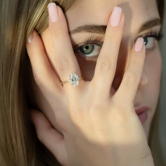 Oval Moissanite Six Prong Thin Band Solitaire Ring in 14K Gold styled on model