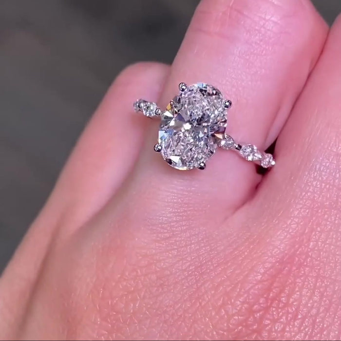 Oval cut moissanite engagement ring with marquise side stones in gold