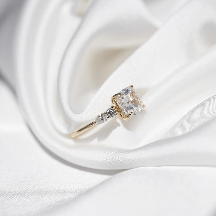 Side view of cushion moissanite cluster accent engagement ring in yellow gold