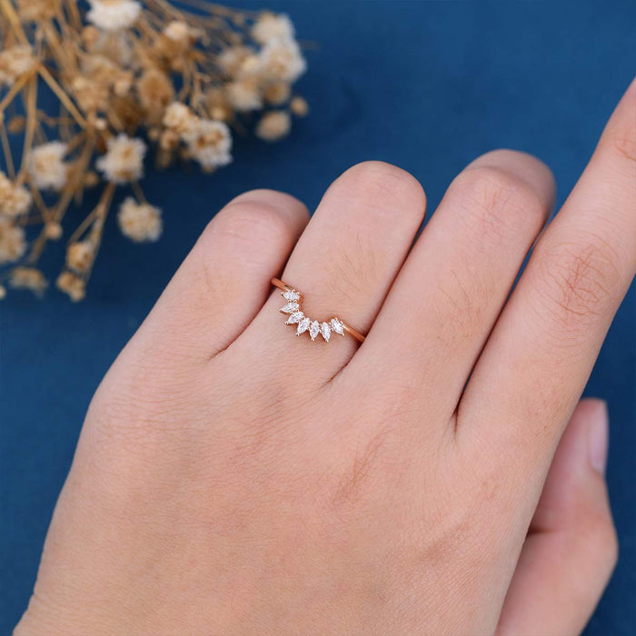 Marquise moissanite curved contour wedding band in rose gold worn on a finger