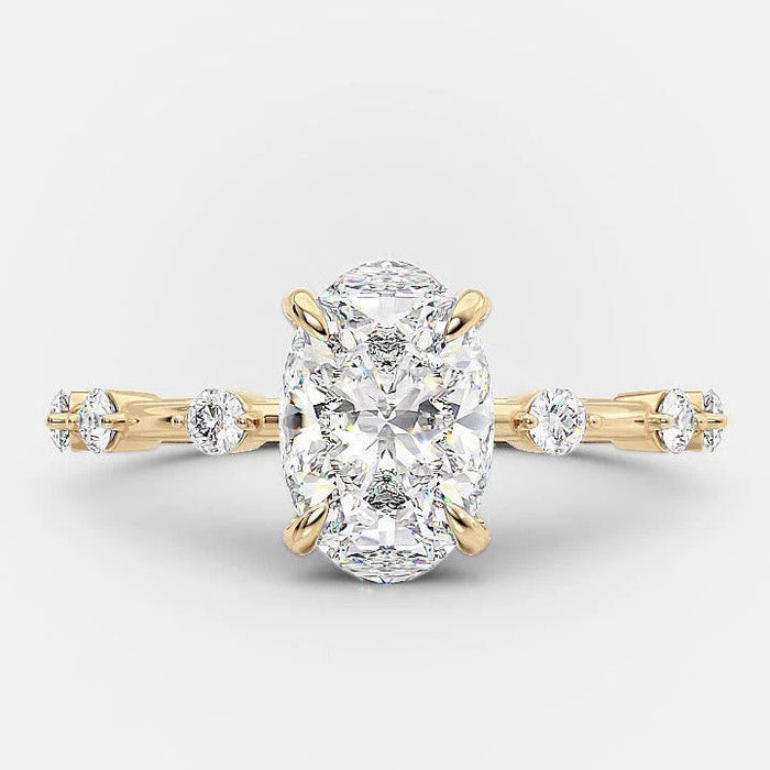 Oval cut moissanite engagement ring with distance pave band in gold